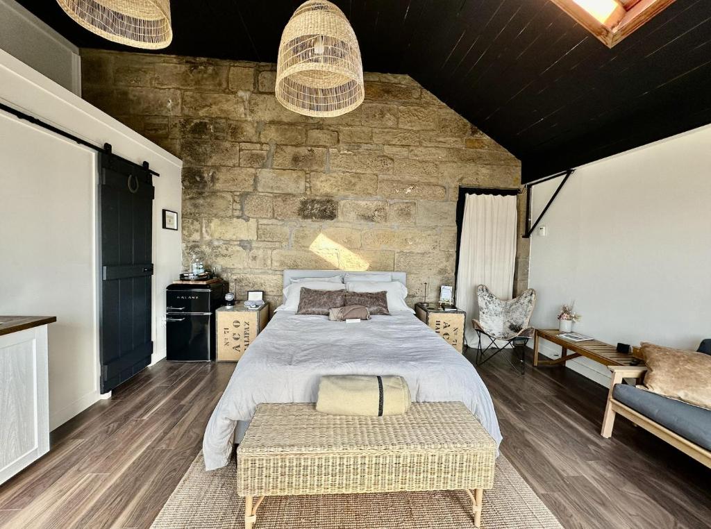 a bedroom with a bed and a stone wall at The Stonehouse Makers' Maisonette in Pictou