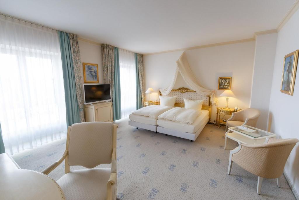 une chambre d'hôtel avec un lit et un canapé dans l'établissement Hotel Erbprinz & Restaurant "Prinzenstube", à Ludwigslust
