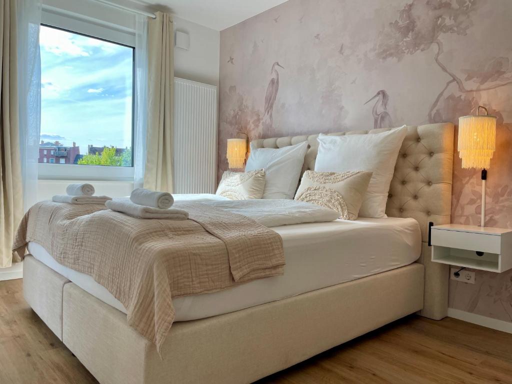 a bedroom with a large white bed with a window at Komm & Bleib Nähe Berlin mit Parkplatz in Falkensee
