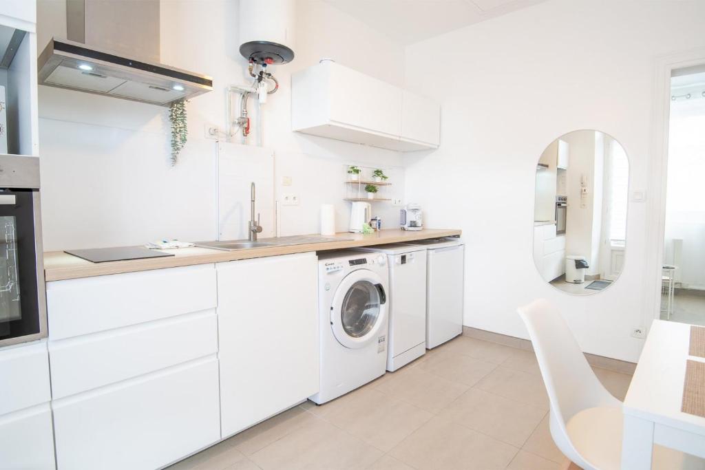 - une cuisine blanche avec lave-linge et sèche-linge dans l'établissement Le Petit Clos'y - Appart hypercentre avec parking + terrasse, à Amboise