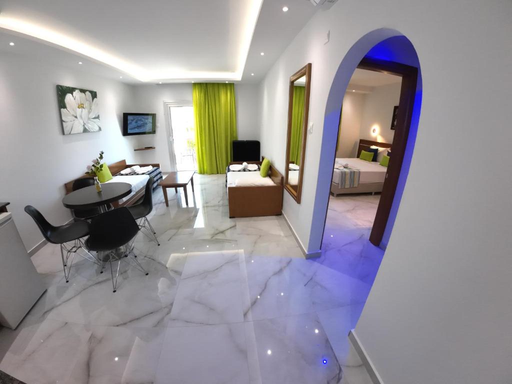 a living room with a table and a room with a couch at Loutsiana Deluxe Apts in Ayia Napa