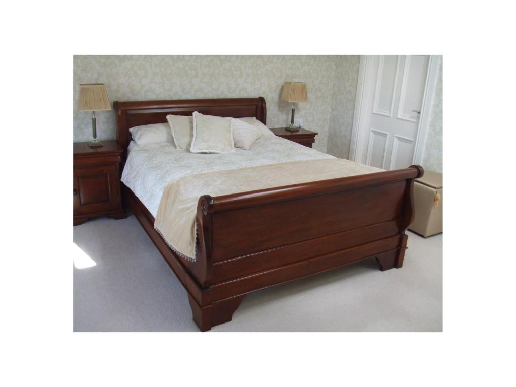 una camera da letto con un grande letto con due comodini di Ambrose Mews B&B a Duncormick