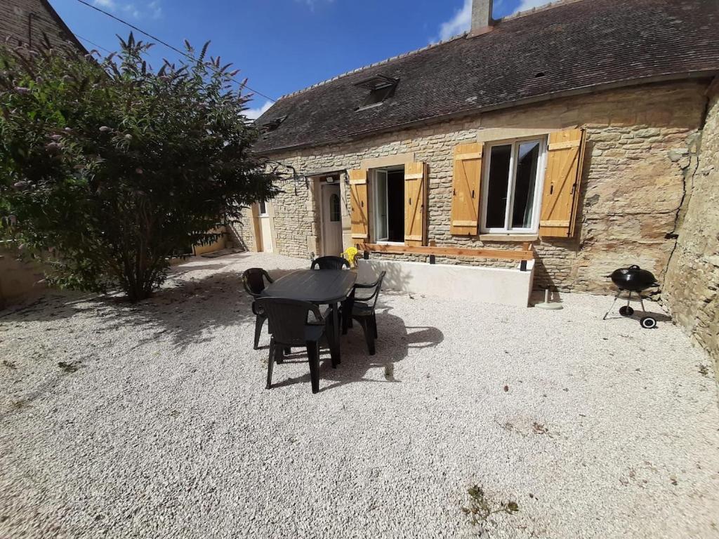 a table and chairs in front of a building at Maison Chez Polo in Étivey