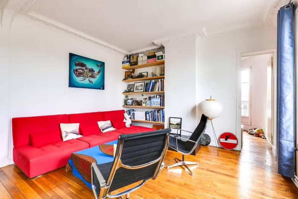 - un salon avec un canapé rouge et une étagère à livres dans l'établissement Comfort and tranquility near the Canal de l Ourcq, à Paris