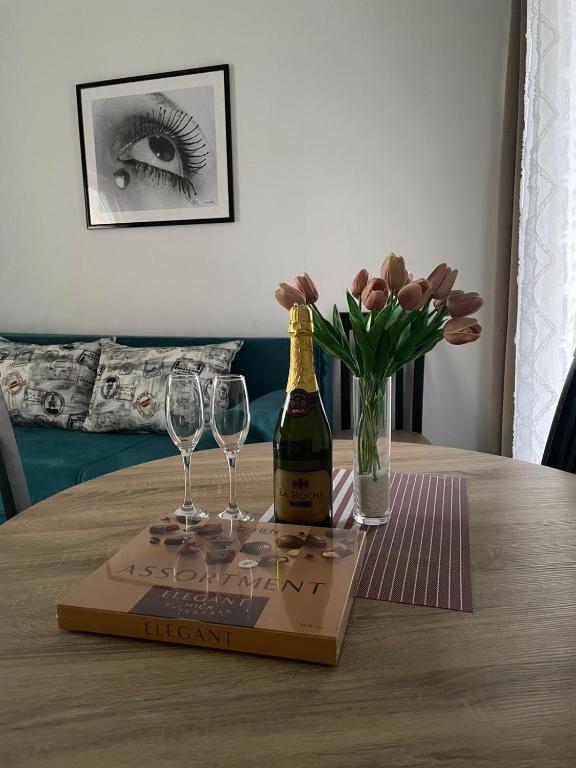 a bottle of champagne and two glasses on a table at Darija in Dobra Voda