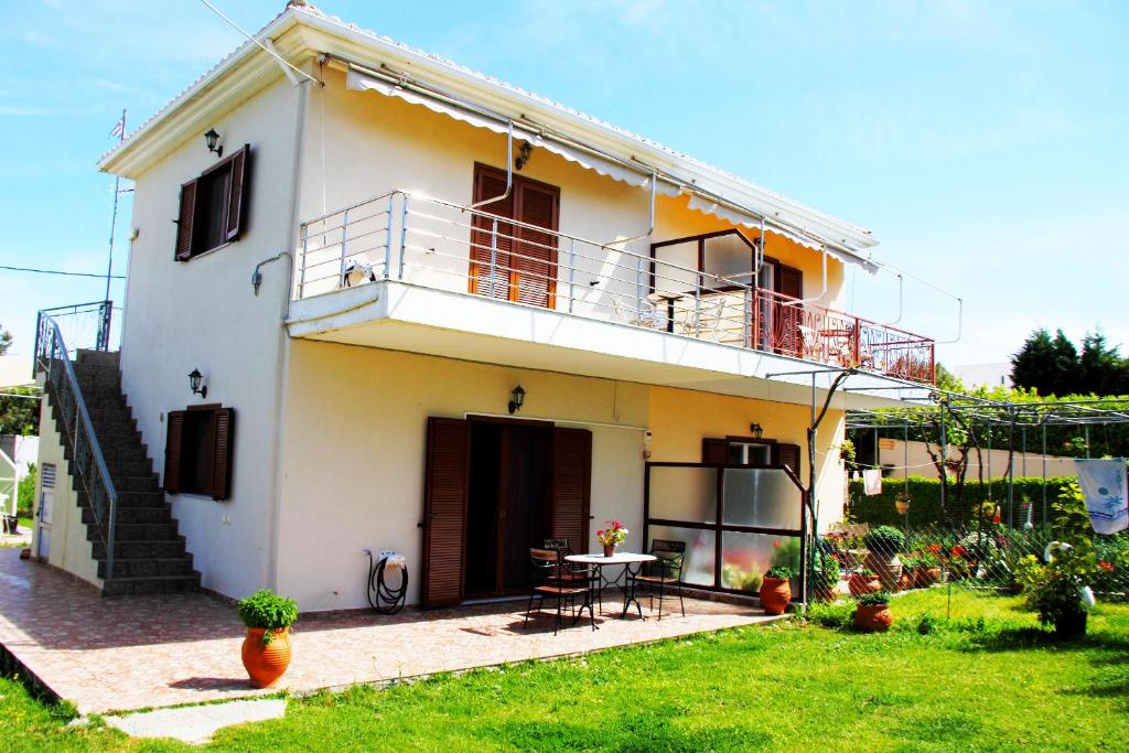 Casa blanca con mesa y balcón en Dimitra Rooms en Lefkada