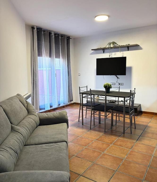 a living room with a couch and a table at Piso bajo con terraza in Mora de Rubielos