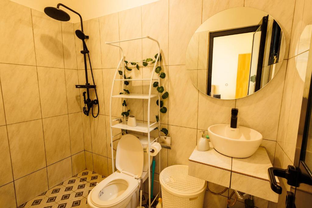 a bathroom with a toilet and a sink and a mirror at Chambre Blanche in Douala