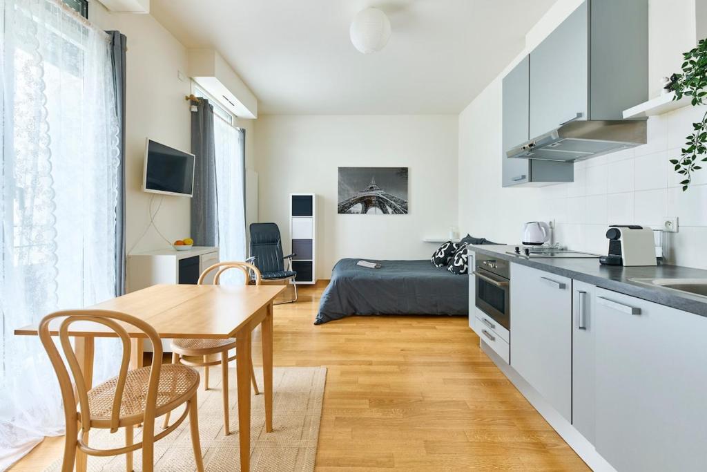 une cuisine et un salon avec une table et des chaises dans l'établissement Direct to Arc de Triomphe, à Paris