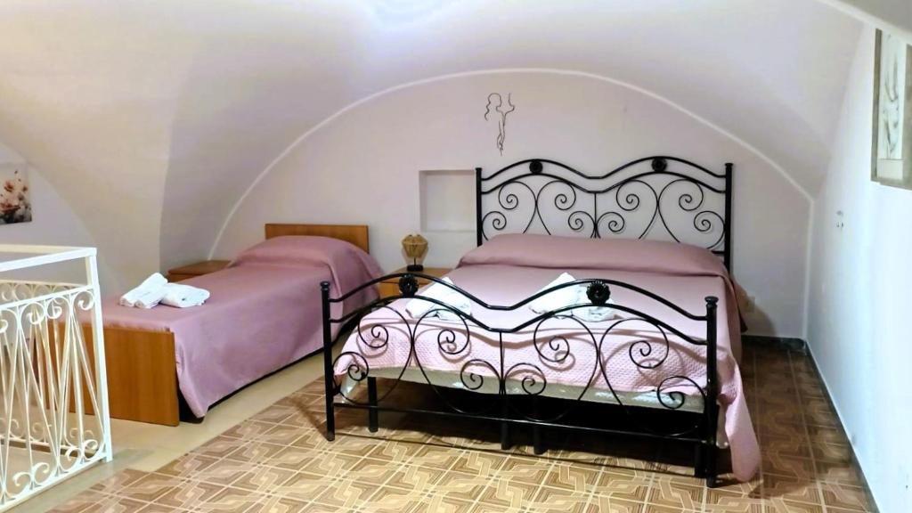 een slaapkamer met twee bedden in een kamer bij Casetta meraviglia in Gaeta