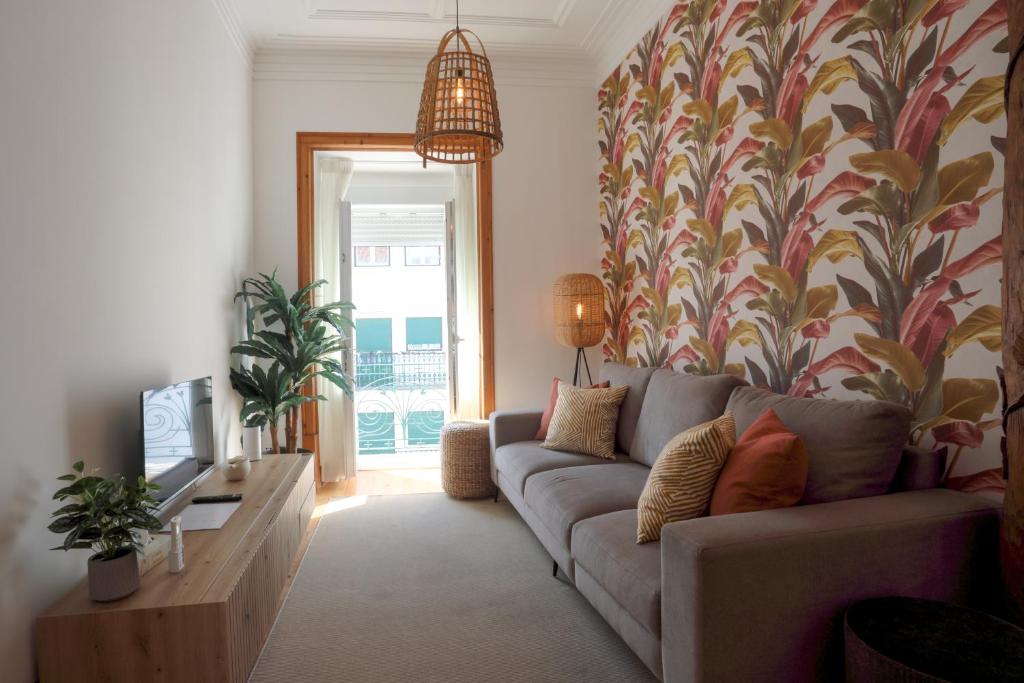 een woonkamer met een bank en een tv bij Casa Ribeiro in Nazaré