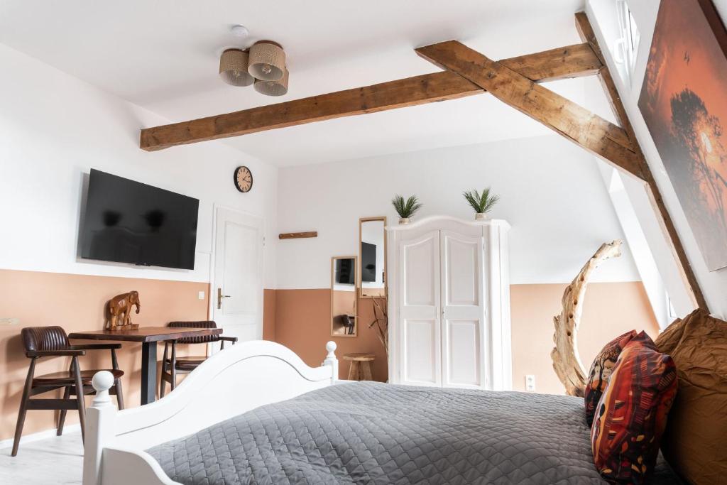 a bedroom with a large bed and a desk at SchaeBu! 5 Apartment Altmarkt goes Afrika in Cottbus