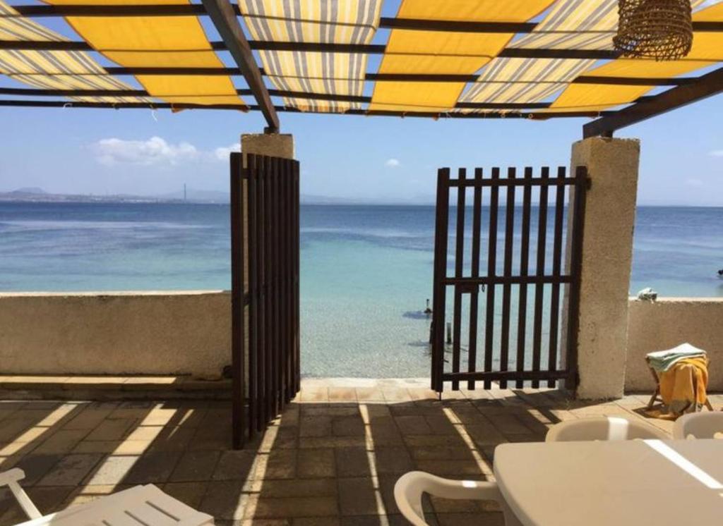 a view of the ocean from a patio with an open gate at villa Francisco in Tatajuba