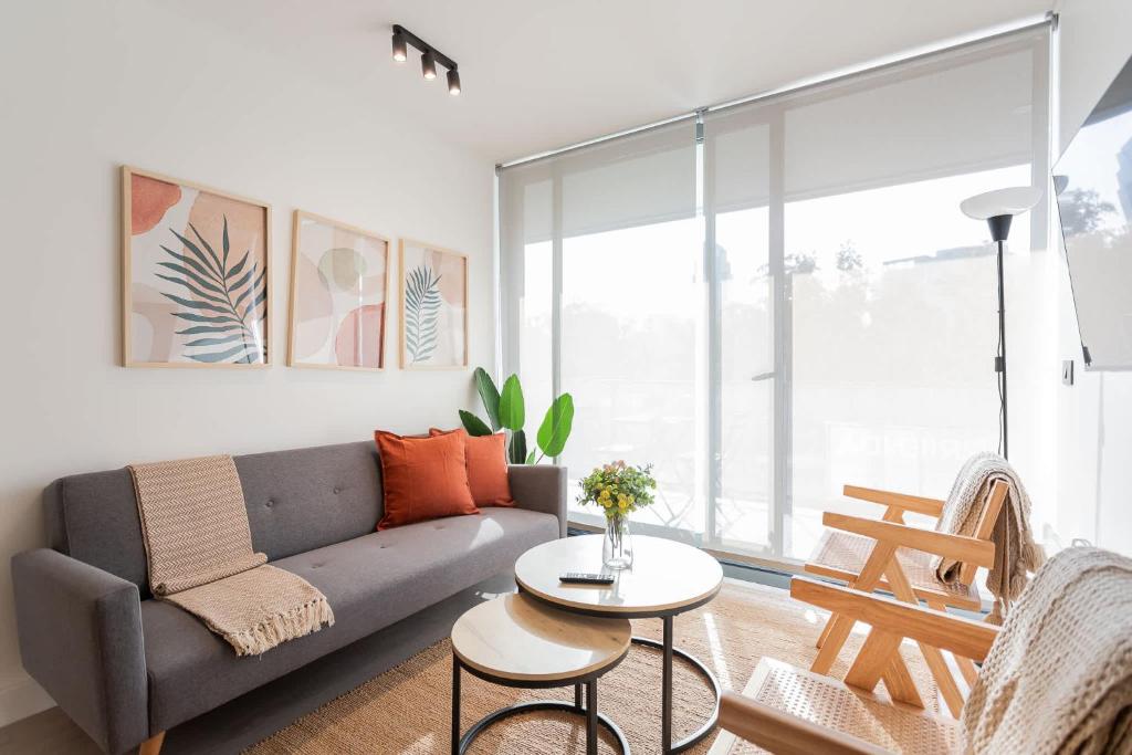 una sala de estar con un sofá y una mesa en Spacious 2BR Apt Top Las Condes Location, en Santiago
