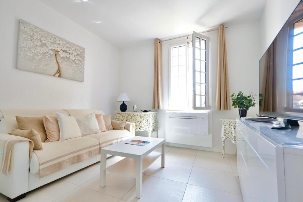 un salon blanc avec un canapé et une table dans l'établissement Le Nine - Apt 2 prs standing Vieil Antibes, à Antibes