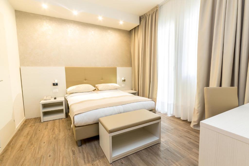 a hotel room with a bed and a large window at Hotel Touring in Lido di Jesolo