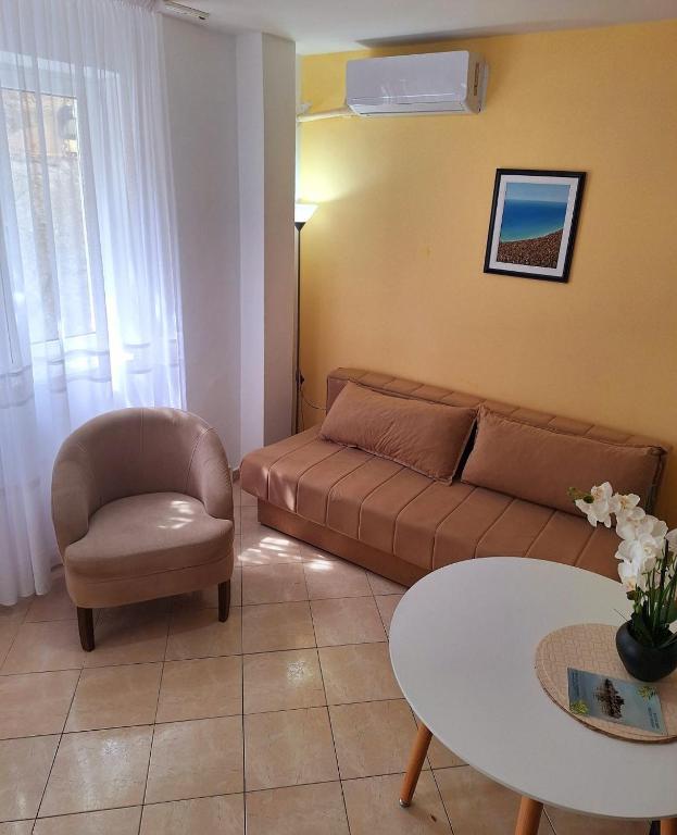 a living room with a couch and a chair and a table at Apartments Mitrovići Miločer in Sveti Stefan