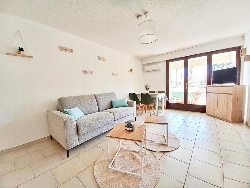 un salon avec un canapé et une table dans l'établissement Studio Cosy Fréjus Plage - Clim, WIFI & Parking, à Fréjus