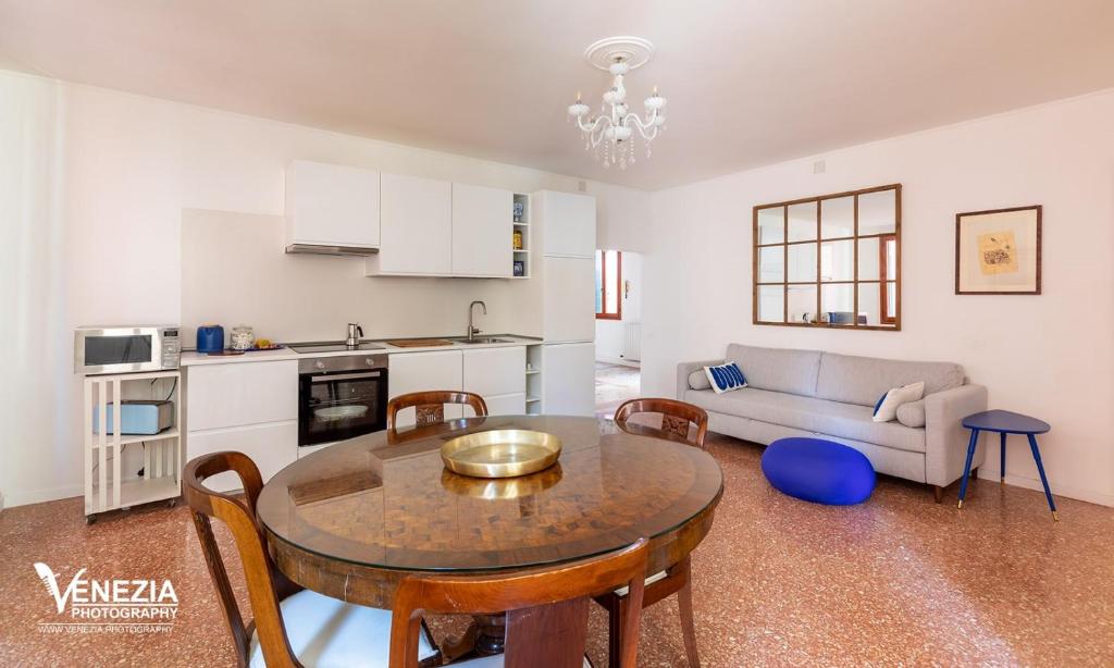 a kitchen and living room with a table and a couch at Ampia Casa a due passi dalla Biennale in Venice
