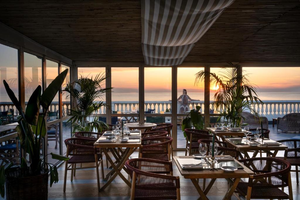 a restaurant with tables and chairs with a view of the ocean at Palace Hotel in Viareggio