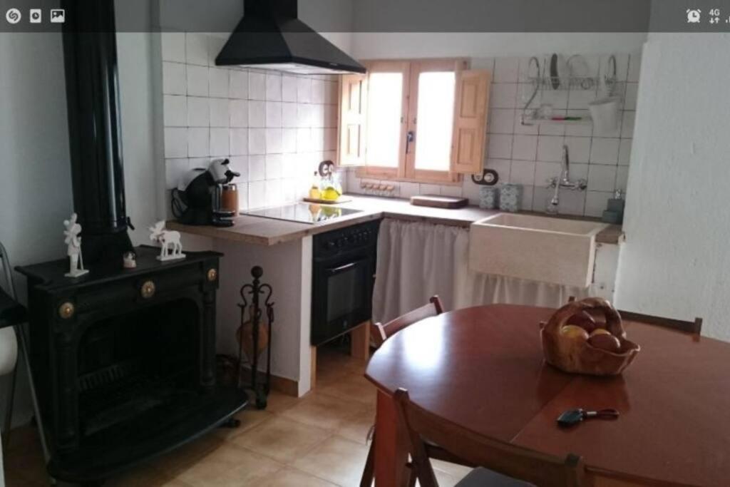 a kitchen with a table and a kitchen with a stove at Casita rural Els voladorets in Torre de Endoménech