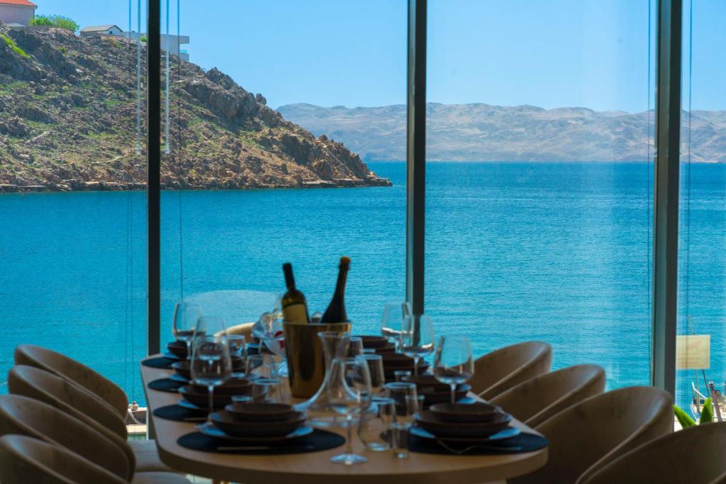 a table with wine glasses and a view of the ocean at Villa Scuola - Beachfront in Cesarica