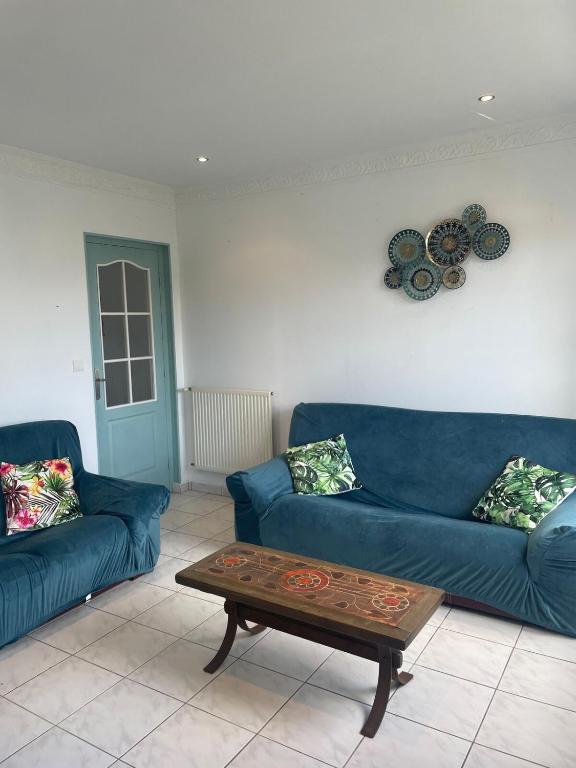 - un salon avec deux canapés bleus et une table basse dans l'établissement Maison à Lilia, à Plouguerneau