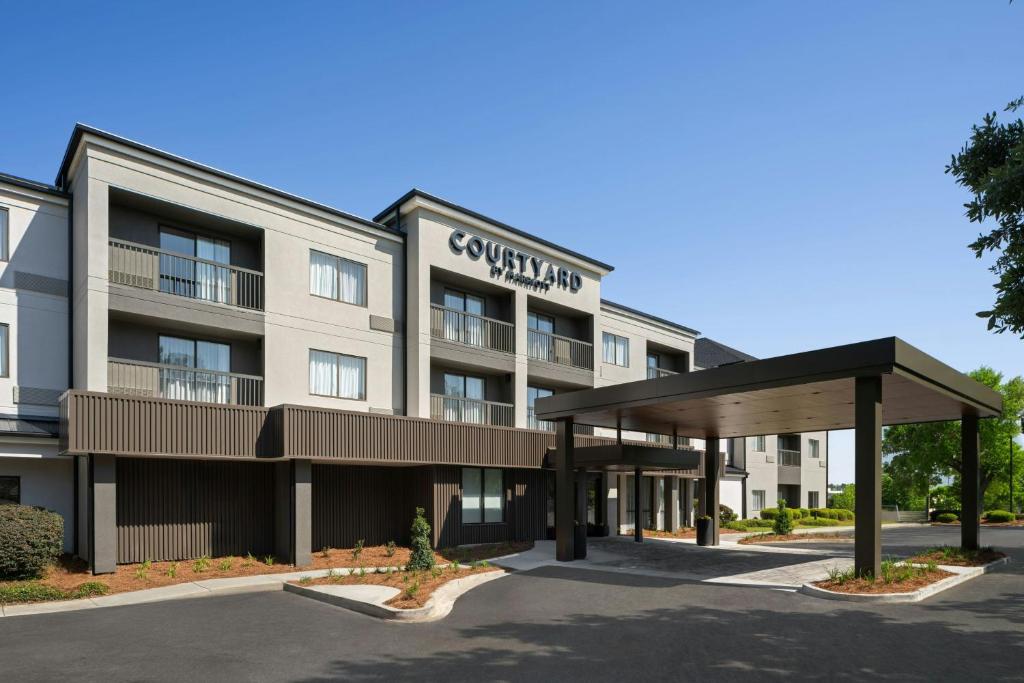 an exterior view of a hotel with a parking lot at Courtyard by Marriott Valdosta in Valdosta