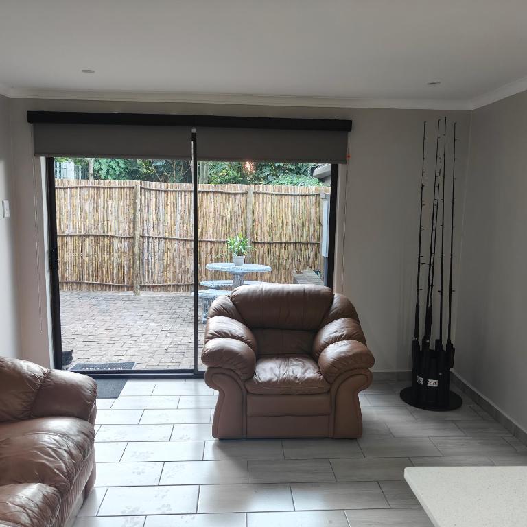 a living room with a couch and a patio at 52 on Marlynhoek Self Catering Apartment in Richards Bay