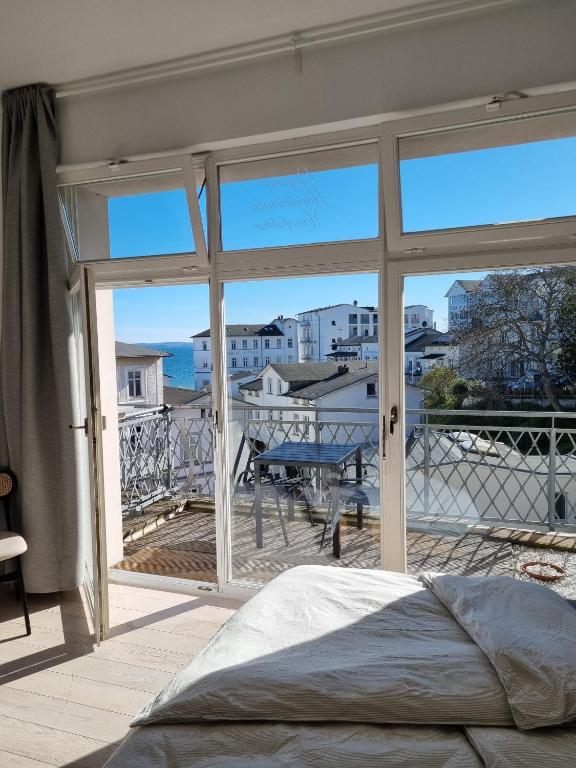 a bedroom with a large window with a view of the city at Apartment mit Meerblick und Südbalkon in Sassnitz
