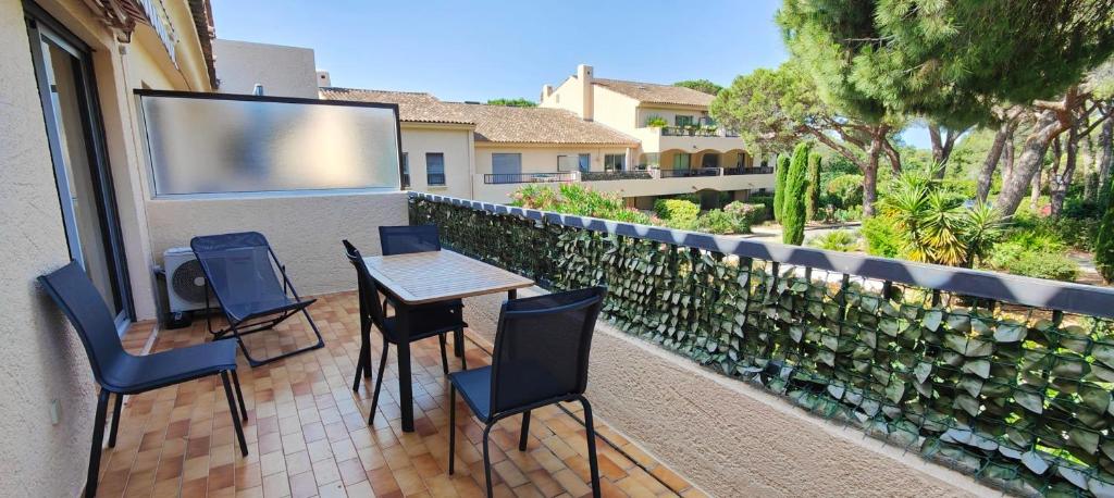 d'un balcon avec une table, des chaises et un paravent. dans l'établissement Charming accommodation with pleasant terrace, à Saint-Raphaël