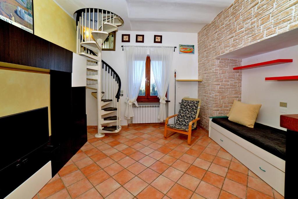 Una sala de estar con una escalera y una silla. en Villa Agello Vista Lago, en Agello