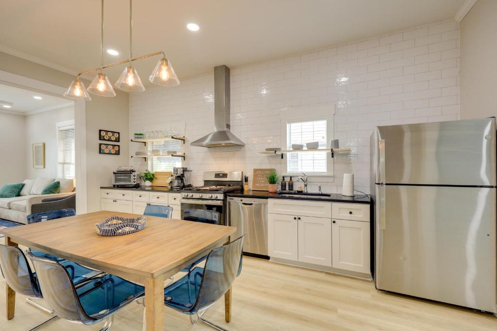 Una cocina con una mesa y un refrigerador de acero inoxidable. en San Antonio Home 2 Mi to Dtwn, Swim Spa!, en San Antonio