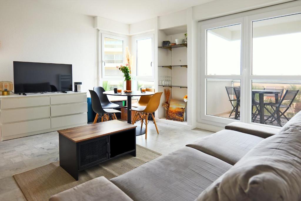 un salon avec un canapé et une table dans l'établissement Appartement Melgueil - Welkeys, à La Grande Motte