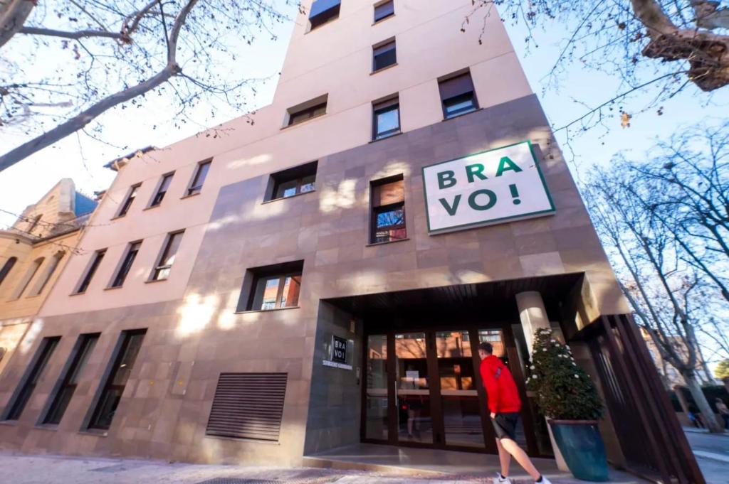 a man walking into a building with a sign on it at For Students Only Bravo Granada in Granada