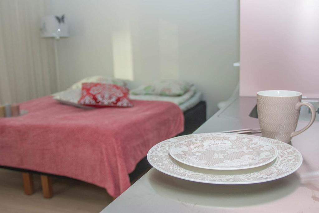 a table with a plate and a cup and a bed at Lahti City Home 1 in Lahti