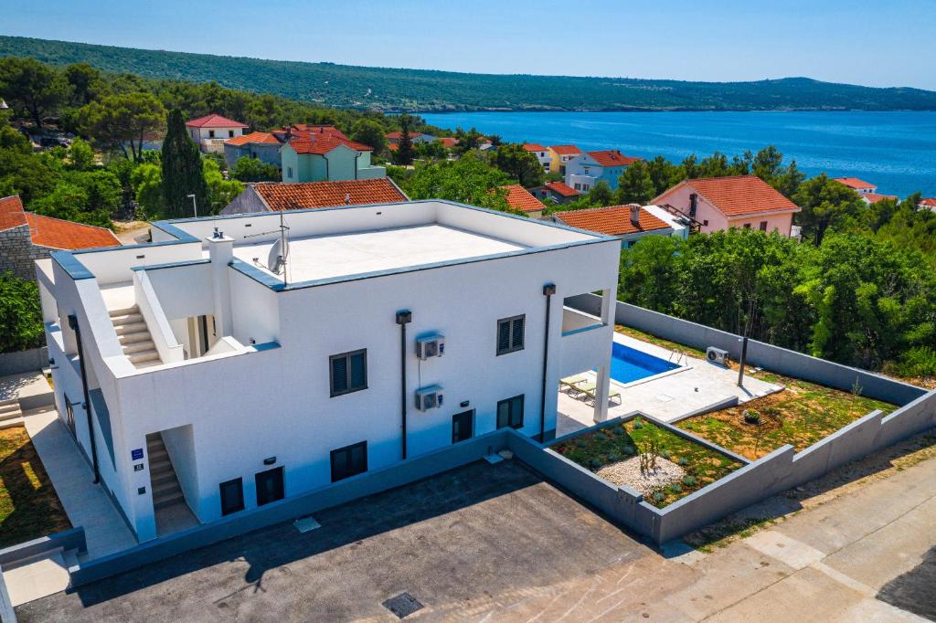 an aerial view of a white house with a swimming pool at Apartment ILUX-3 in Novigrad Dalmatia