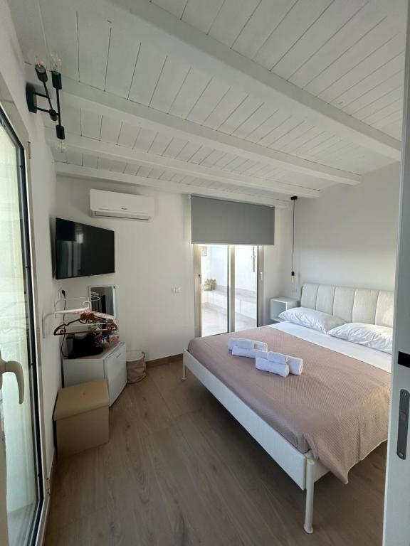 a bedroom with a large bed with two towels on it at AZ rooms in Noto