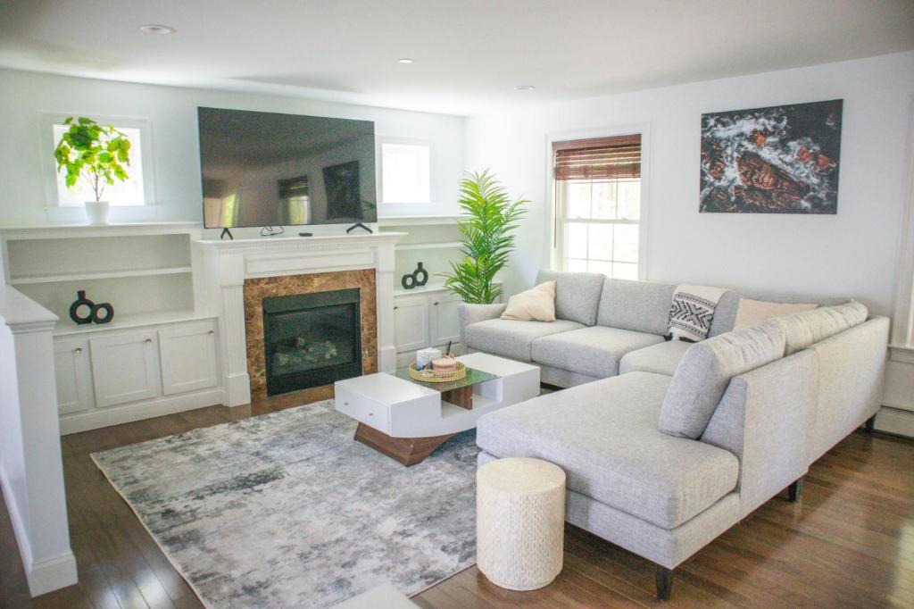 a living room with a couch and a fireplace at The Cityside Maple House in Falmouth