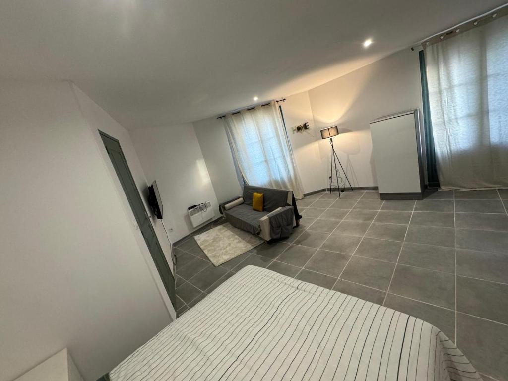 un salon avec un canapé et une fenêtre dans l'établissement Studio meublé confort Béziers, à Béziers