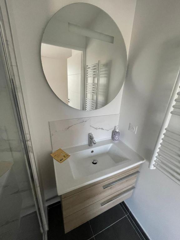 un bagno con lavandino e specchio di 14th view Paris a Malakoff