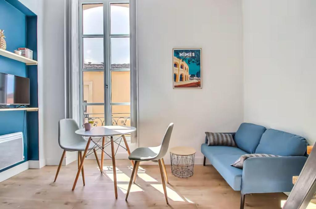 un salon avec un canapé, une table et des chaises dans l'établissement Le Méridien-Studio Cosy en plein centre, à Nîmes