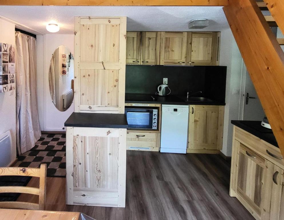 a kitchen with wooden cabinets and a counter top at Résidence Les Avenieres - LES AVENIERES - AV02D MAE-2144 in Villarodin-Bourget