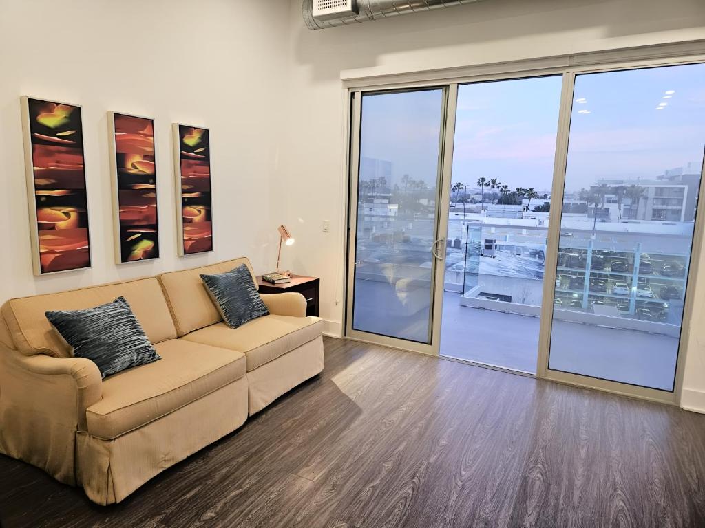 a living room with a couch and a large window at Modern Venice Beach Stay - Walk to Marina & Boardwalk in Los Angeles
