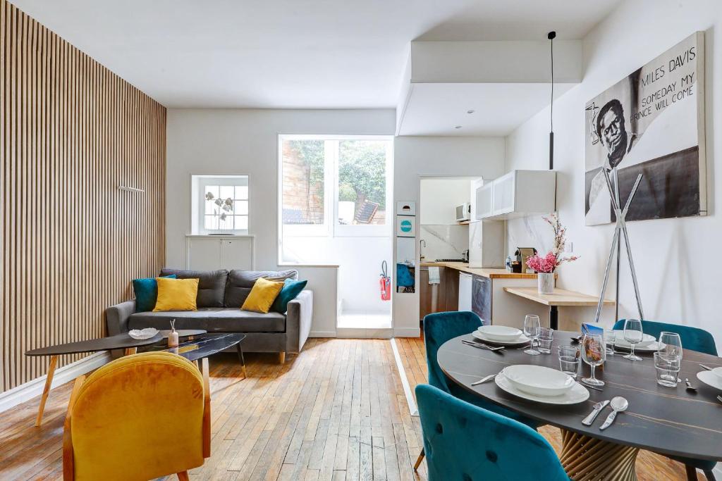 un salon avec une table, des chaises et un canapé dans l'établissement Chic Terrasse a 5min des Champs-Elysees with AC, à Paris