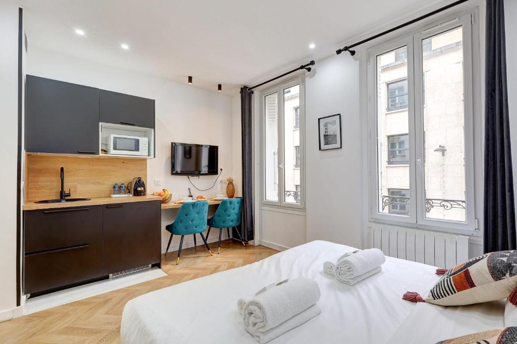 Cet appartement comprend une chambre avec un lit et une cuisine avec un comptoir. dans l'établissement Charmant logement renove proche des champs with AC, à Paris