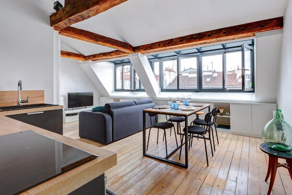 une cuisine et un salon avec une table et des chaises dans l'établissement Un Eclat de Lumiere en Plein Paris, à Paris