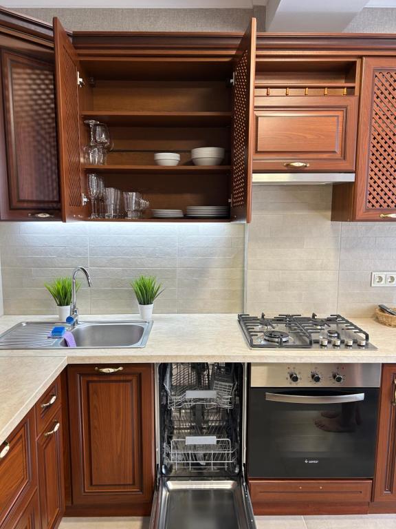 a kitchen with wooden cabinets and a dishwasher at Gold in Chişinău