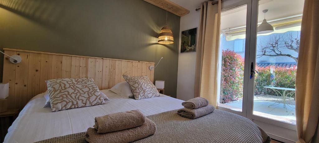 a bedroom with a bed and a large window at Sous le tilleul in Gréoux-les-Bains