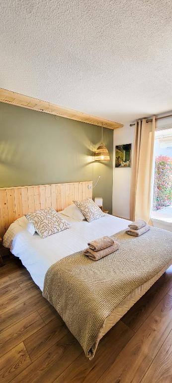 - une grande chambre avec un grand lit et des draps blancs dans l'établissement Sous le tilleul, à Gréoux-les-Bains